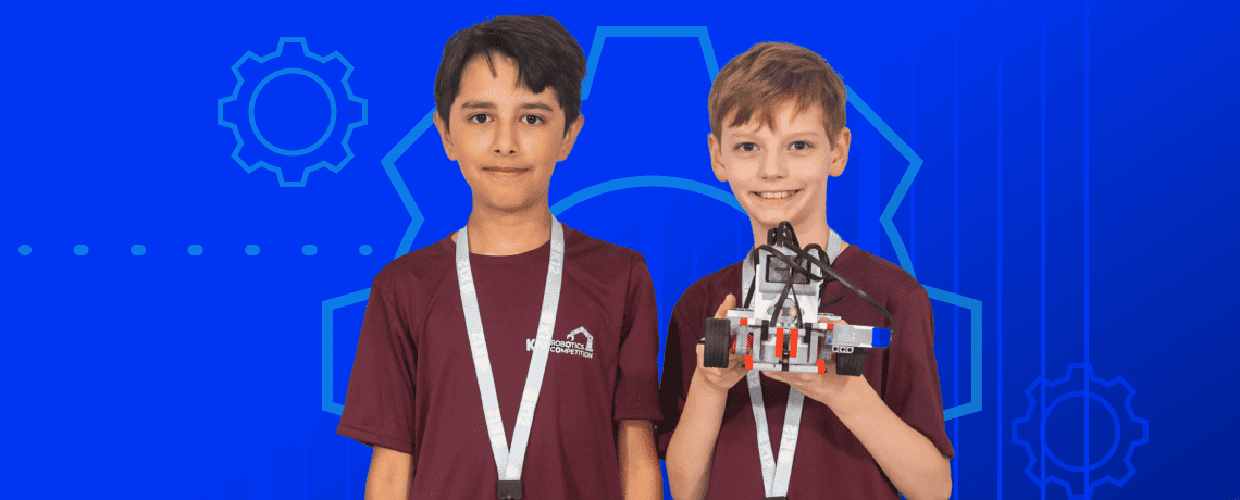 Two boys proudly hold up a robot against a vibrant blue background, showcasing their excitement and creativity.