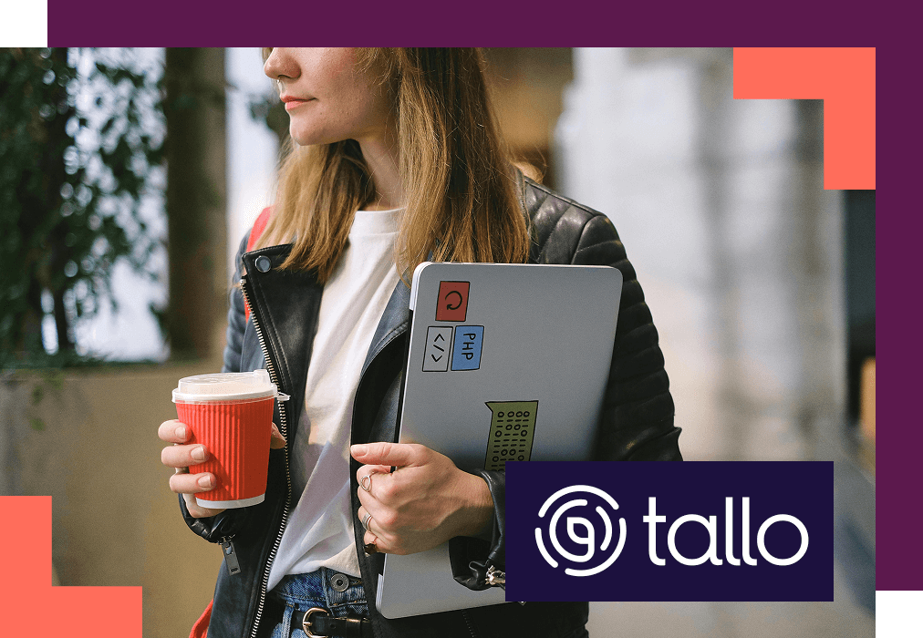 Woman in a leather jacket holds a laptop with tech stickers and a red coffee cup, walking inside. Tallo logo overlays the image, suggesting a tech theme.